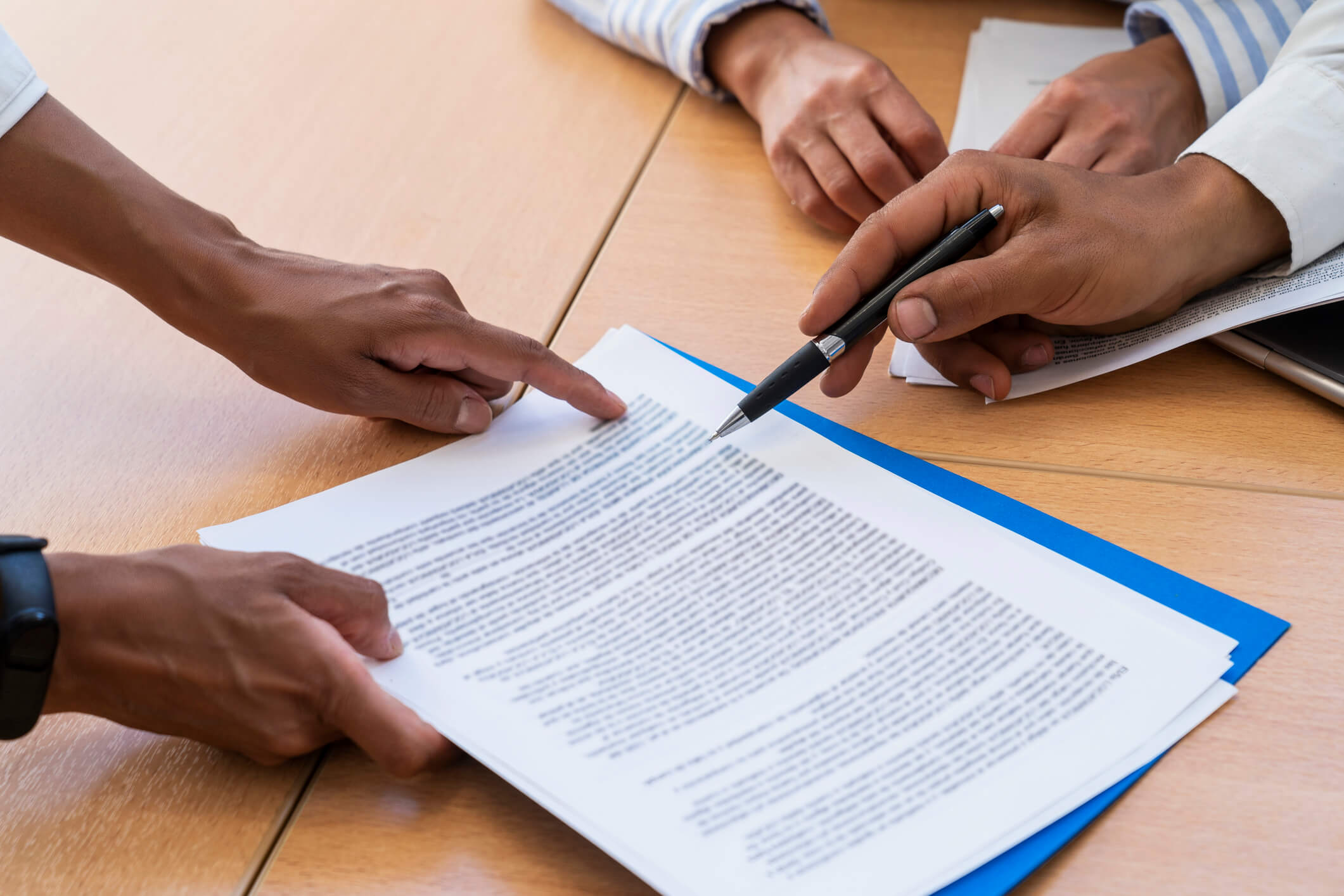 Hands pointing at business contract