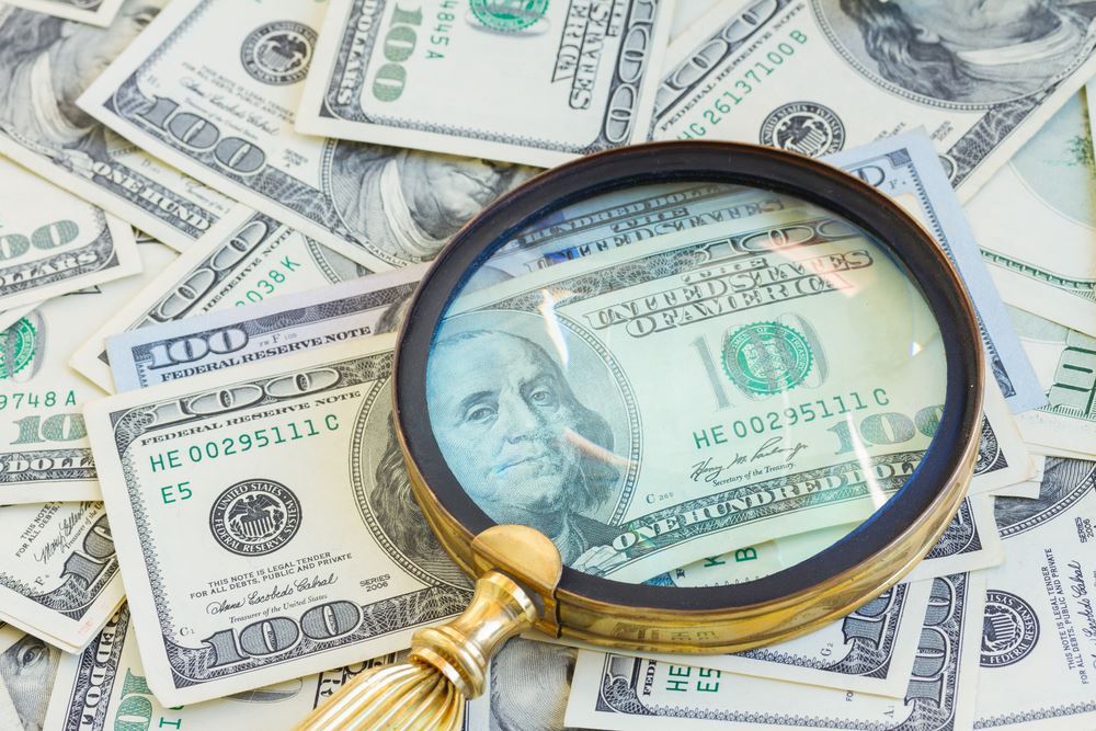 money and magnifying glass