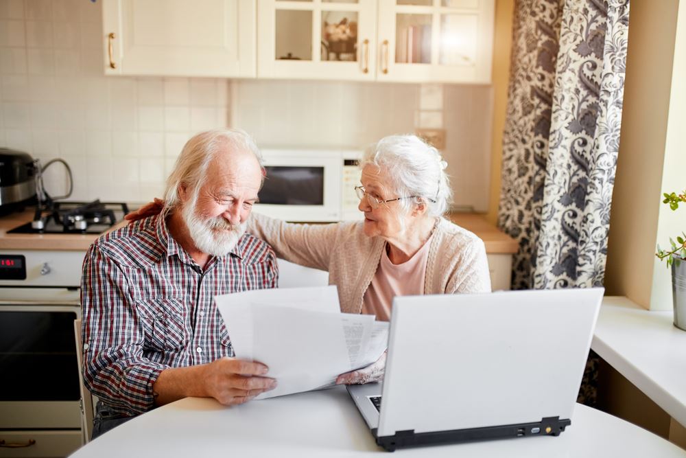 Elderly woman using a magnifying glass to view document
